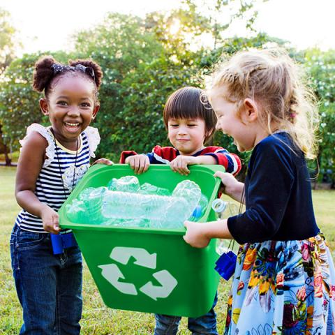 A group of children cleaning up plastic bottles.