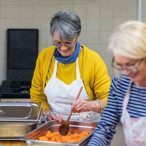 Une aînée prépare des légumes pour une banque alimentaire