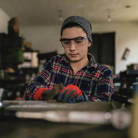 Une jeune personne répare une bicyclette dans un garage