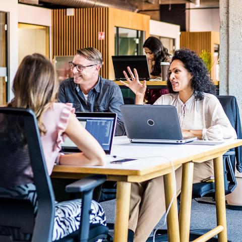 Des personnes assises à une table ont une discussion animée et positive.