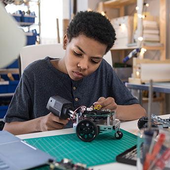 A young man works on a robotics project.
