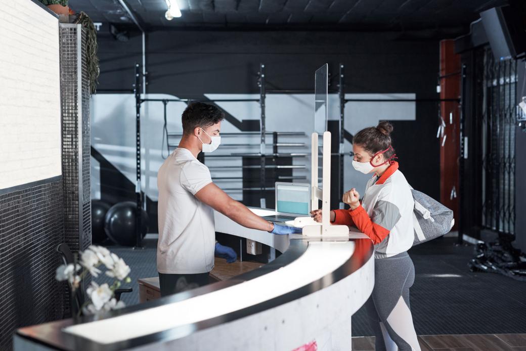 Une jeune femme s'inscrit au bureau d'accueil d'un gym.