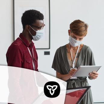 Two people in an art gallery wearing masks