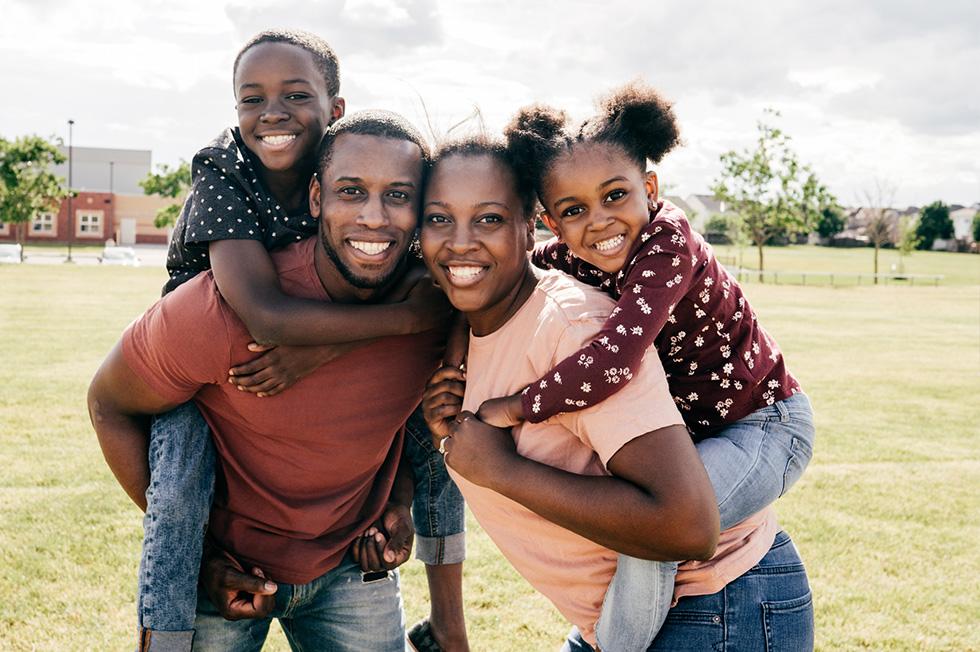 An outdoor family portrait with two parents and two kids.