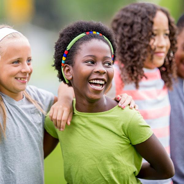 Des jeunes amis s’amusent dehors et sourient