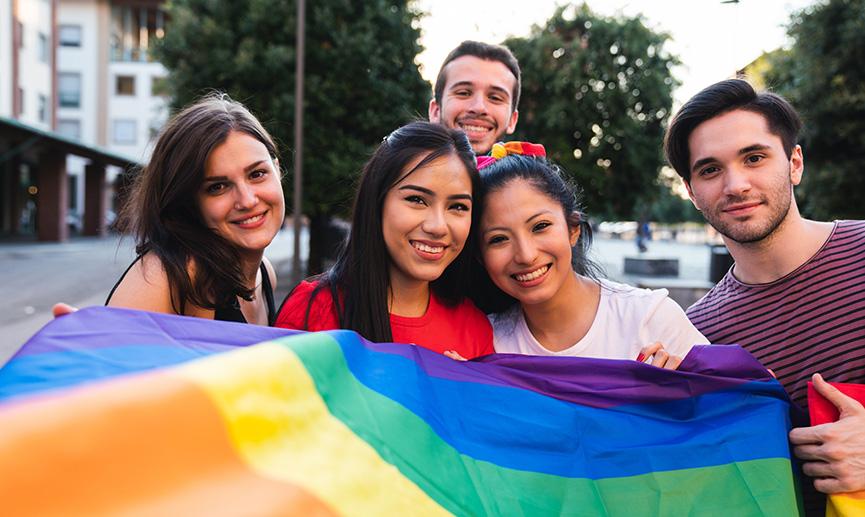 Youth are proudly holding a Pride flag in the street