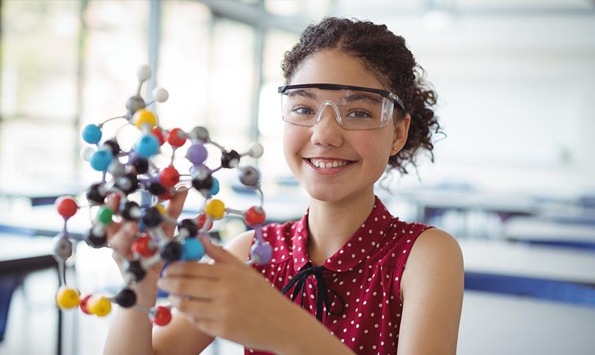 A young girl works on a science experiment in class. 