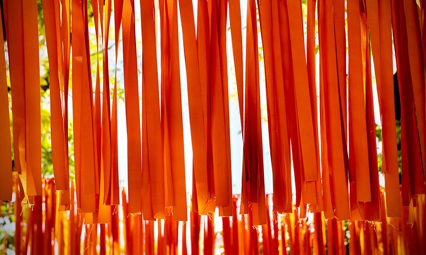 Orange ribbons hanging from a wire to represent Indigenous children who died at residential schools in Canada. 