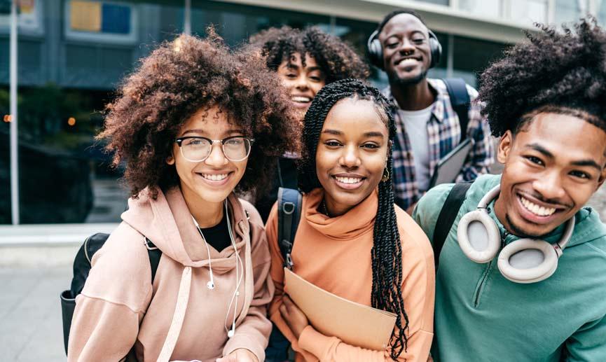 A photo of a group of young friends smiling in an urban outdoor setting.