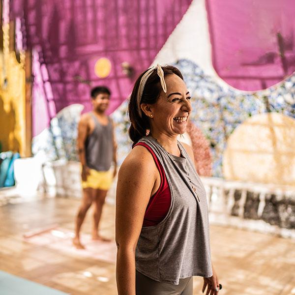 Une adulte rit lors d’un cours de yoga.