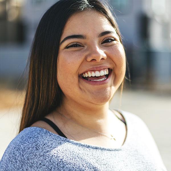 A close up of a young person smiling.
