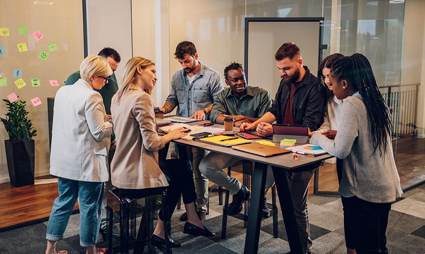 A group of coworkers are sitting around a table having a business meeting 