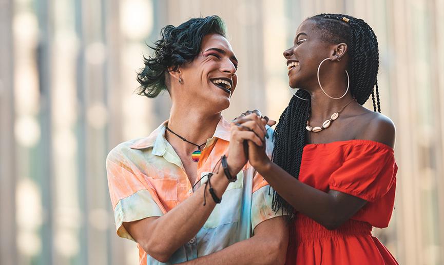 Two happy friends are smiling and holding hands