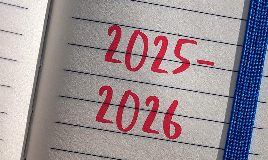 The year 2025 and 2026 written on a notepad .