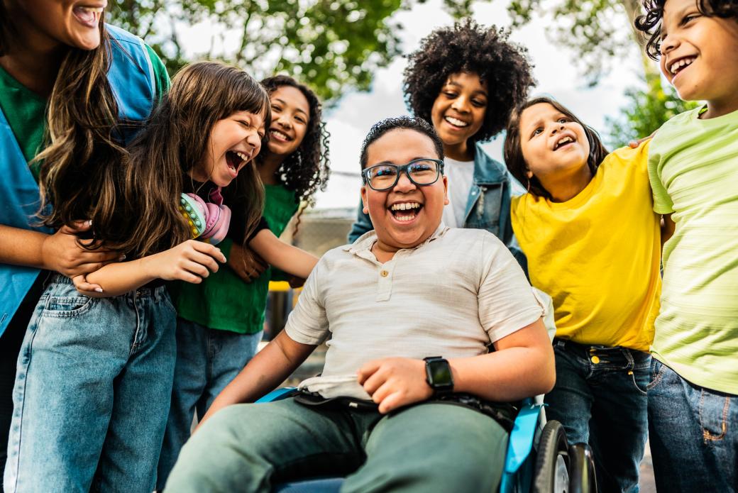 Un groupe d'enfants contents sourit dehors