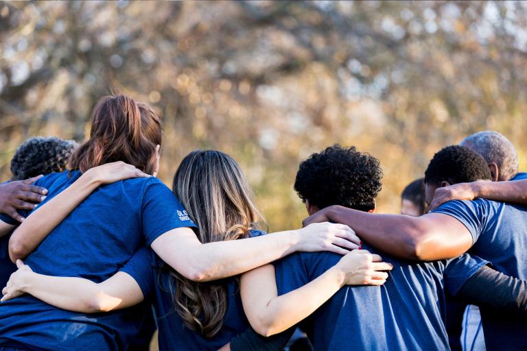 Friends linking arms in unity.