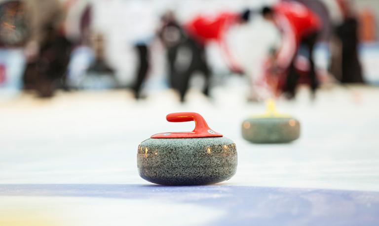 Un gros plan sur une pierre de curling sur une piste de curling. 