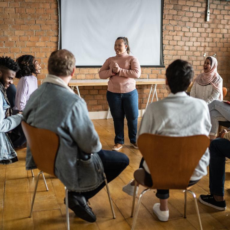 Young woman with special needs talking in a group meeting.