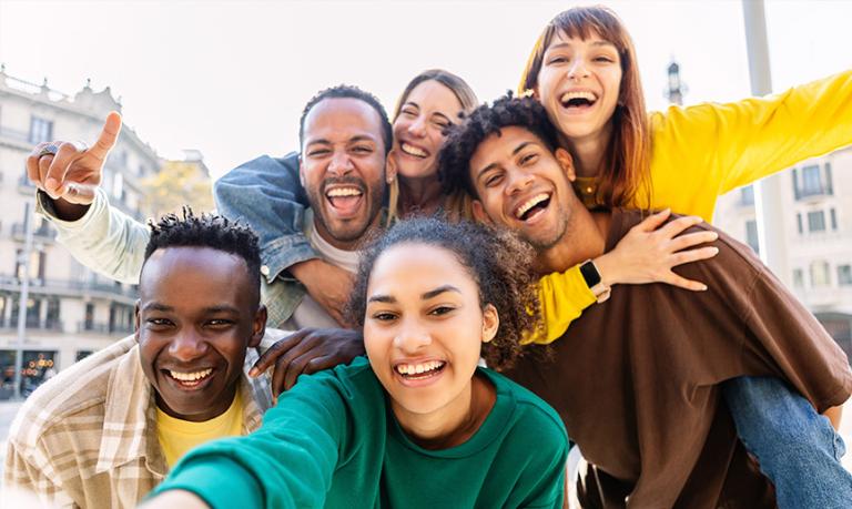 Un groupe de jeunes heureux et multiraciaux se prend en photo en ville.